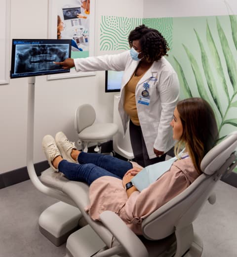 A woman receives dental care and is shown her X-rays at Walmart